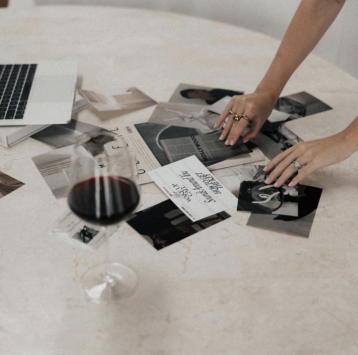 Editorial tearsheets and campaign prints laid out on a marble table