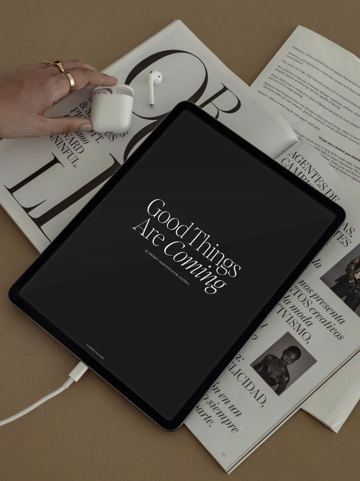 Tablet reading “Good Things Are Coming” on a stack of fashion magazines